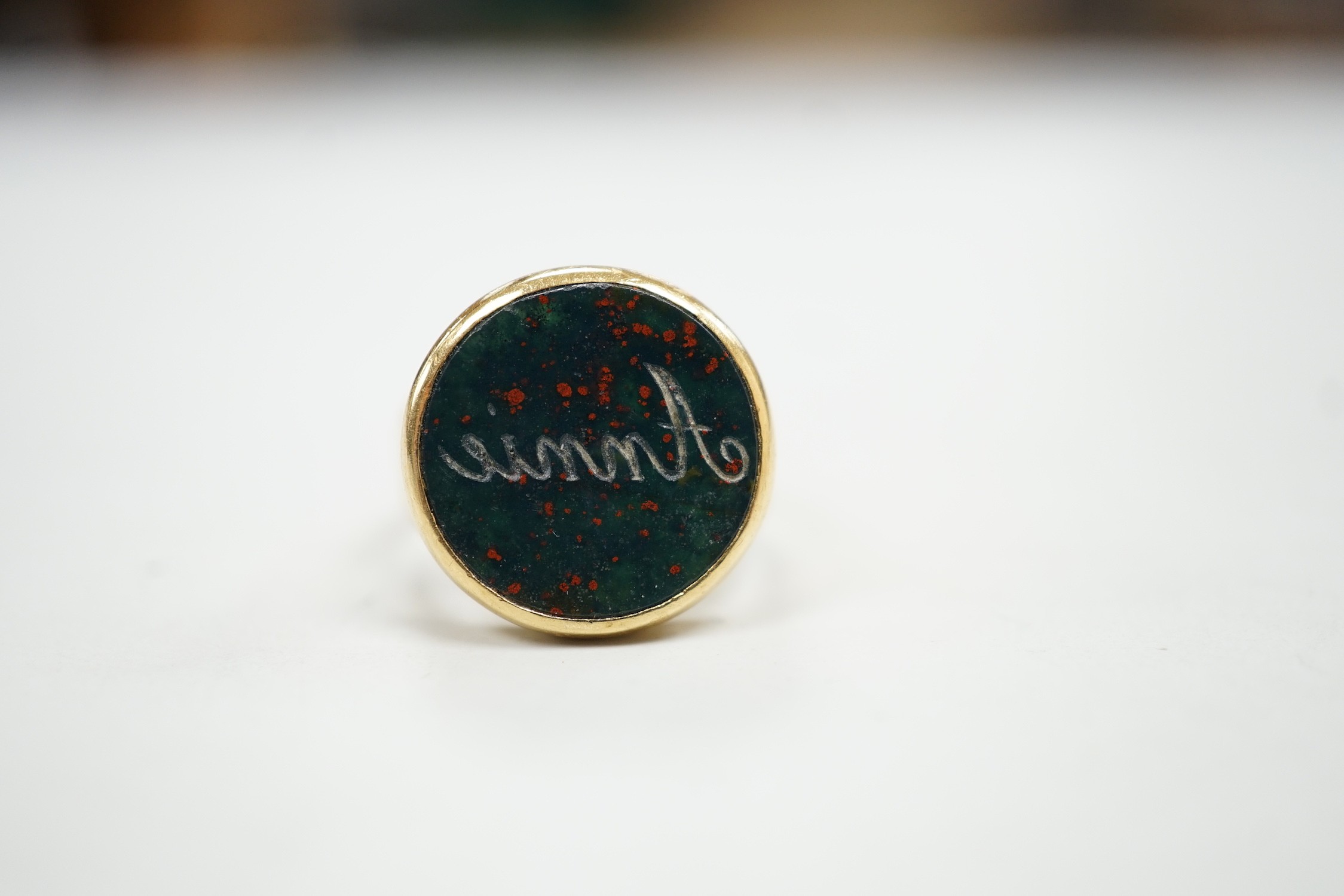 An 18ct and bloodstone set signet ring, carved with the name 'Annie', size H, gross weight 4.9 grams.